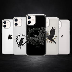 May include: Five clear phone cases with raven designs. The cases display different raven illustrations, including a silhouette, a raven on a branch, a raven in flight, and a raven with floral accents. The designs are in black and white.