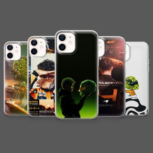 May include: A collection of phone cases featuring Formula 1 racing themes. The cases display images of drivers, helmets, and racing scenes. The cases are in various colors, including black, green, and orange, and are designed for a smartphone.