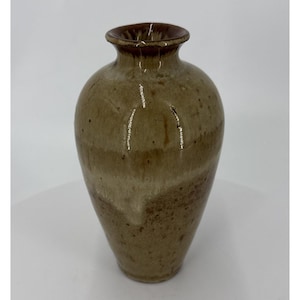May include: A handcrafted ceramic vase with a rounded body and a narrow neck. The vase features a gradient of earthy tones, transitioning from a dark brown rim to lighter beige and tan hues. The vase is approximately 8 inches tall.