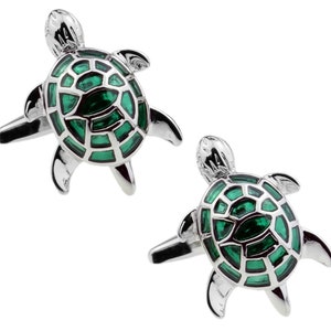 May include: A pair of silver turtle cufflinks with green enamel detailing. The turtles have a detailed shell design.