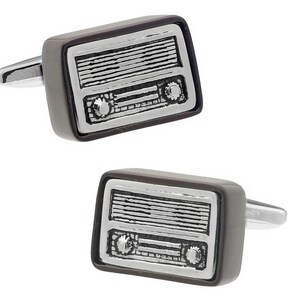 May include: A pair of cufflinks featuring a vintage radio design. The cufflinks are silver with a brown enamel finish.