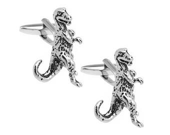 May include: A pair of silver dinosaur cufflinks. Each cufflink features a detailed dinosaur design.