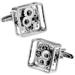 May include: A pair of silver cufflinks with a square design featuring a gear mechanism inside. The gears are silver with black accents.