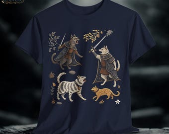 Op de afbeelding: Marineblauw t-shirt met een fantasie-illustratie van katten in harnas, zwaaiend met zwaarden. Het ontwerp bevat bloemen- en bladeren elementen, met de merknaam "W.Y.R.M. & WICK" in de linkerbovenhoek.
