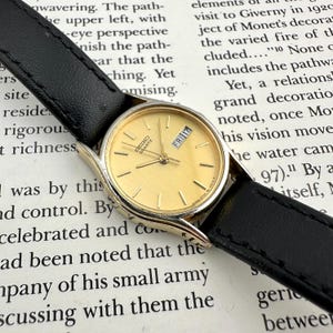 Reloj Seiko para mujer, dorado, esfera redonda pequeña, correa de cuero negro, estilo vintage de los 90, elegante y delgado, regalo retro, funciona perfectamente.
