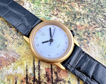 Vintage Guess Damenuhr, goldfarbenes Gehäuse, silbernes Zifferblatt, schwarzes Lederarmband, klassisch minimalistischer Stil, funktioniert gut