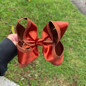 Handgemachte Schleife aus Satin und Glitzer in Rostrot, Babyschleife, Boutique Schleife