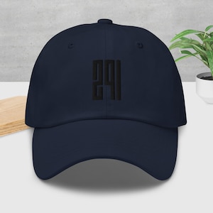 Op de afbeelding: Een marineblauwe baseballpet met de geborduurde letters "291" in zwart. De pet heeft een gebogen klep en een verstelbare band aan de achterkant. De hoed is gemaakt van een zachte, duurzame stof.