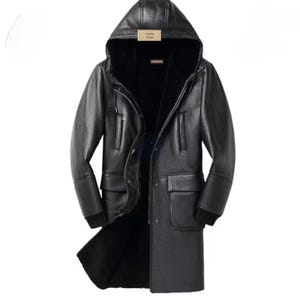 May include: A black leather hooded coat with a fur lining. The coat has a button-up front, two front pockets, and a label that reads "Jacket Crate". The sleeves have black ribbed cuffs.