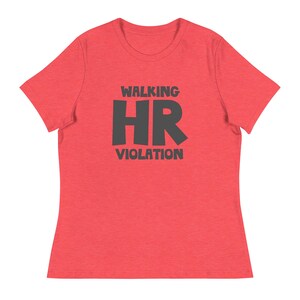May include: Red t-shirt featuring the phrase "WALKING HR VIOLATION" in dark grey block letters. The top has a crew neck and short sleeves. The material looks soft and lightweight.