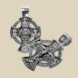 Puede incluir: Dos colgantes de cruz ortodoxos plateados. Las cruces presentan grabados intrincados de figuras religiosas y texto. Una cruz se muestra con su fianza, y la otra sin ella. Las cruces se muestran sobre un fondo neutro.