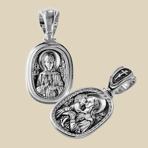 May include: Two silver pendants with religious iconography. One pendant features a woman with a halo, and text. The other pendant depicts a woman holding a child. Both pendants have a loop for a chain.
