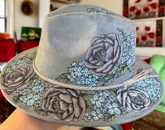 Hydrangea peony short brim fedora. Hand-burned using a wood burning tool, then hand painted. Vegan suede hat is a dusty blue color.