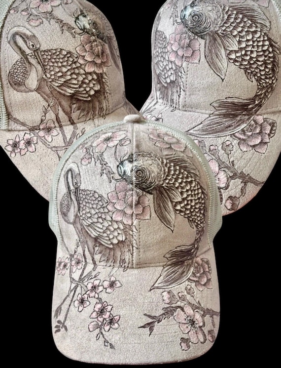 Cherry blossoms, koi, and crane, hand-burned using a wood burning tool. A touch of acrylic accent paint. Grey vegan (faux) suede, mesh back.