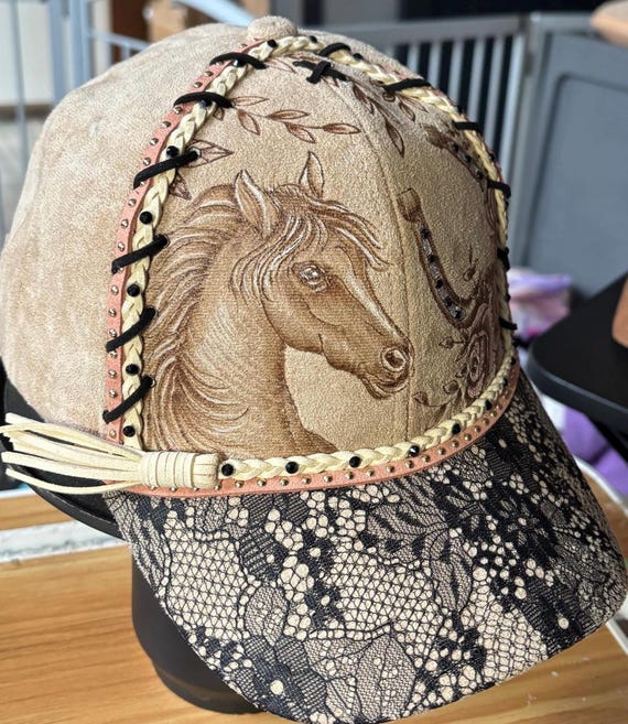 Horse and horseshoe with roses, hand-burned using a hand held wood burner. Beige faux suede cap with black lace brims and leather lacing.