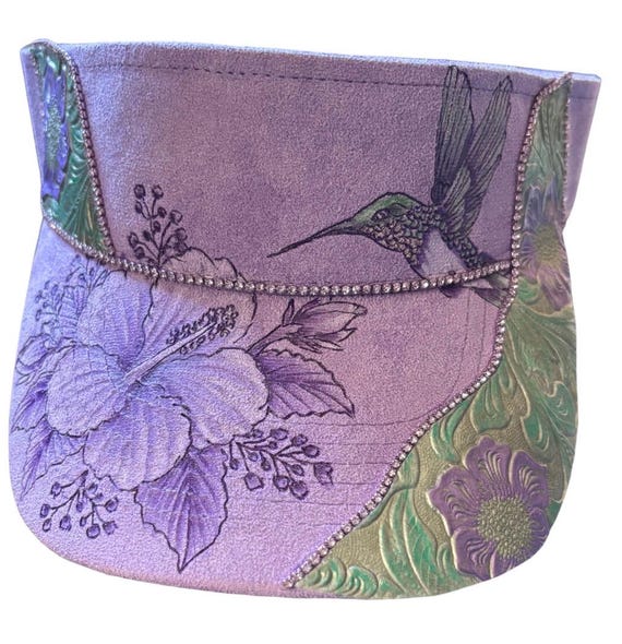 Hibiscus and hummingbird, Hand- burned. Vegan (faux) suede purple visor. Hand painted accent, tooled faux leather and Rhinestones.