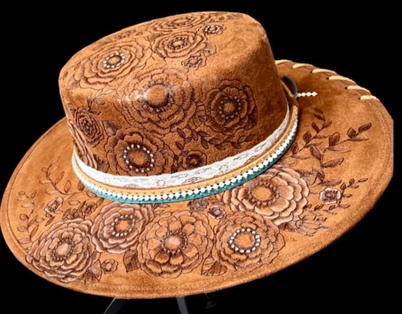 Floral free-hand hand-burned (using a wood burner), white acrylic paint accents, Wide Brimmed Hat, round flat top, Leather studded lacing.