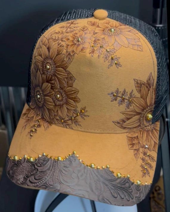 Hand-Burned sunflowers, Saddle Tan Vegan Suede Ball Cap, Black mesh back. Faux leather on brim, gold accent stones, bronze rhoneatones.
