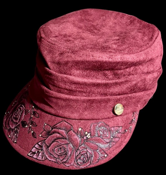 Hand-burned wine colored newsboy cap, champagne colored rhinestone accents. Faux Suede, inner string sizer