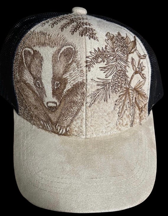 Badger in the woods, hand-burned using a hand held wood burner. Vegan (faux) suede tan with black mesh back. Unique for badger fans!