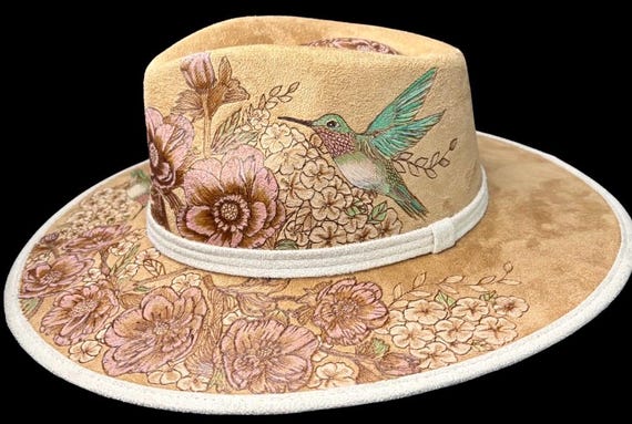 Adorable hummingbird, hand-burned using a wood burner, then hand painted. Hard body rancher. Size medium. Wearable art!