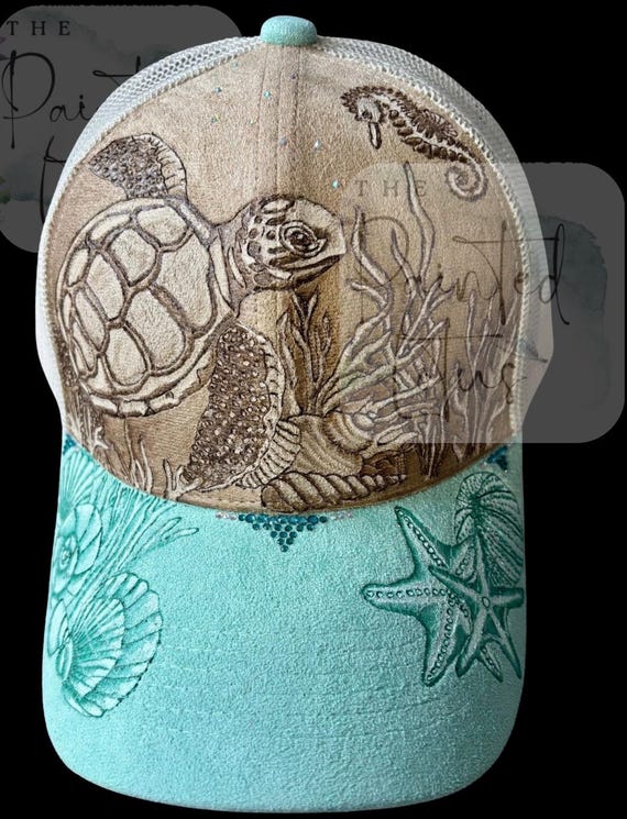 Sea turtle, seahorse and shells, hand-burned Vegan (faux) suede ball cap. Highly detailed, on a duo color, ponytail back ball cap.