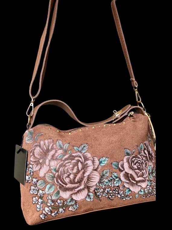 Faux Suede Hand-Burned and painted rose design, brown hand bag/purse. Bronze studs, and dangling side charms. Detachable shoulder strap.