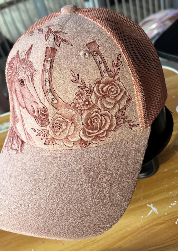 Horse and horseshoe hand-burned, faux suede pink ball cap. Mesh ponytail back.