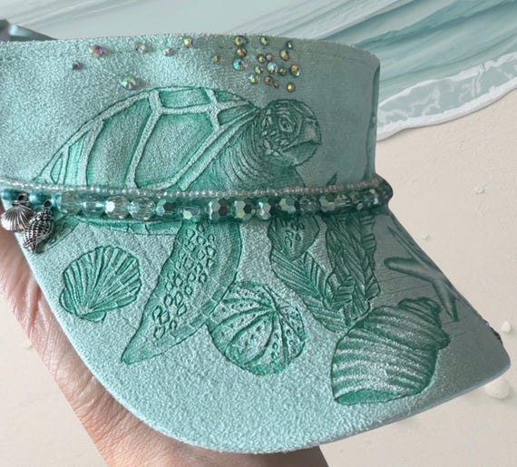 Sea turtle, sea shells, hand-burned, Vegan (faux) suede light green visor. Gems, beads, charms and rhinestones.