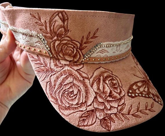 Butterfly and roses, hand-burned, Vegan (faux) suede peacock dusty pink visor. Lace, studded faux leather lacing, and rhinestones.