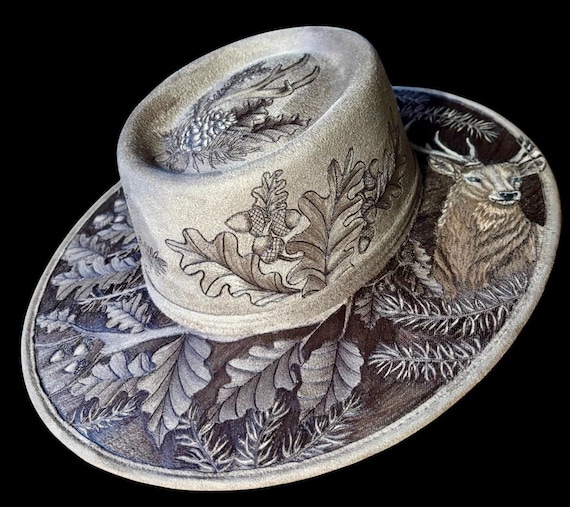 King Of The Pines, Hand-Burned brown Vegan Suede, oval top, hard body wide brim hat. Size medium.A gorgeous, detailed work of wearable art!