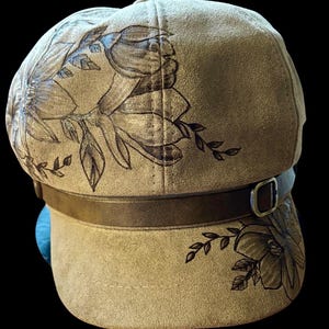 Hand-Burned, vintage newsboy cap, beautiful magnolias. Camel brown vegan suede, inner pull string sizer. One size fits most adults.