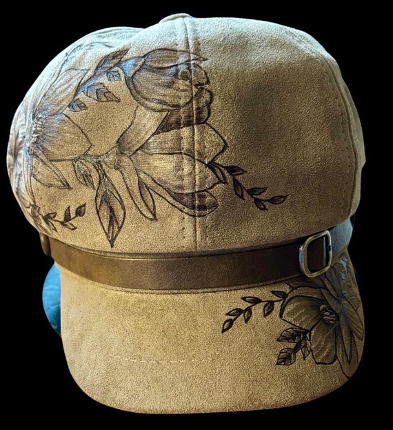 Hand-Burned, vintage newsboy cap, beautiful magnolias. Camel brown vegan suede, inner pull string sizer. One size fits most adults.