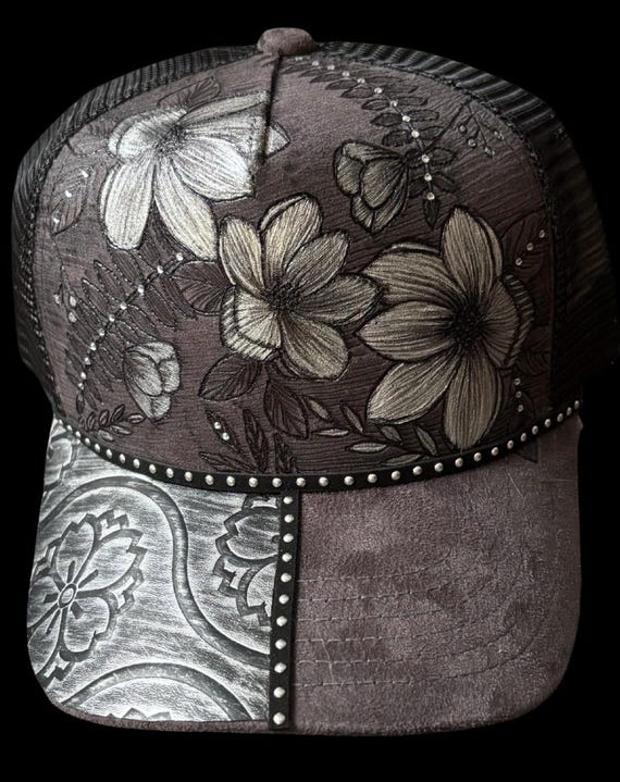 Hand-Burned gray trucker hat, black mesh snap back. Floral with silver painted accents. Can add personalized wording.