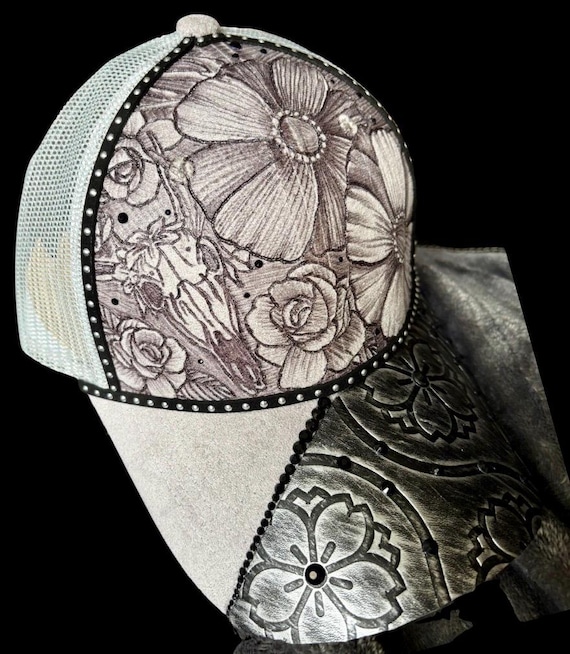 Hand-burned grey and black faux suede ball cap, free-hand burned floral, deer skull, with black Rhinestones & tooled leather brim.