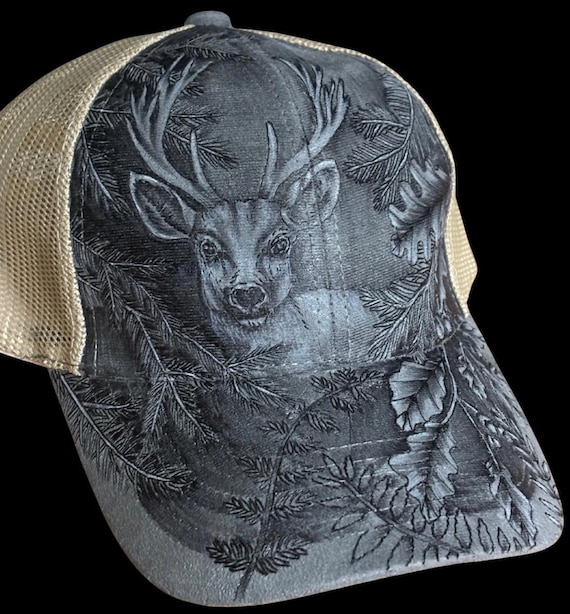 Buck in the moonlight woods, hand-burned using a hand held wood burner. Faux suede with tan mesh ponytail back. Unique one of a kind.