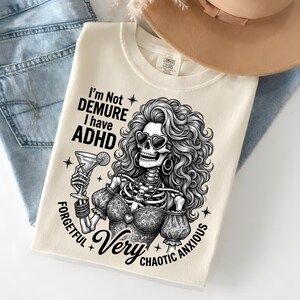 Könnte beinhalten: Cremefarbenes Sweatshirt mit einer Grafik einer Skelettfrau mit herzförmiger Sonnenbrille, die einen Cocktail hält. Der Text lautet "I'm Not Demure I have ADHD Forgetful Very Chaotic Anxious."