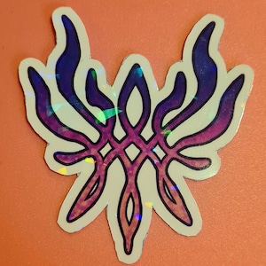 May include: A holographic sticker featuring a stylized, symmetrical design with a central diamond pattern. The sticker has a white border and a color gradient from purple to pink, with blue accents. The design resembles a stylized flower or emblem.