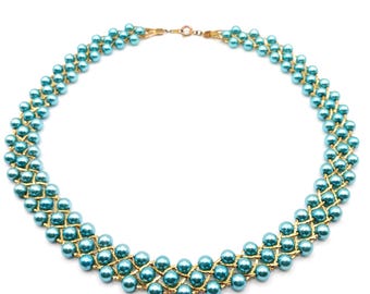 May include: A multi-strand necklace featuring rows of round, glossy turquoise-colored beads woven together with a textured gold-tone metal lattice structure. The piece is secured with a small, circular gold-tone metal clasp at the top center.