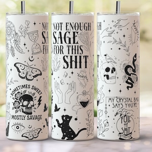 Könnte beinhalten: Drei weiße Edelstahlbecher mit schwarzen Strichzeichnungen. Die Designs umfassen einen Traumfänger, eine Sanduhr, eine Motte, einen Totenkopf, Hände, eine Katze und die Sätze "NOT ENOUGH SAGE FOR THIS SHIT", "SOMETIMES SWEET MOSTLY SAVAGE" und "MY CRYSTAL BALL SAYS YOU'RE FULL OF SHIT".