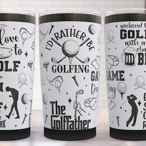 May include: Three white insulated tumblers with black lids, each featuring golf-themed graphics and text. The designs include golf balls, clubs, and phrases like "Love to Golf" and "Eat. Sleep. Golf. Repeat."
