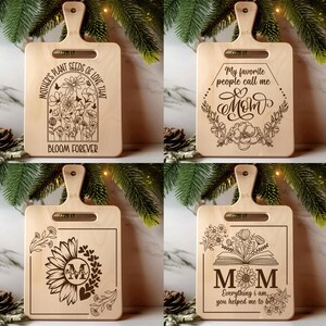 Puede incluir: Cuatro tablas de cortar de madera con asas, cada una grabada con un diseño diferente. Una tabla presenta flores y el texto "Mother's plant seeds of love that bloom forever." Otra dice "My favorite people call me Mom." Las otras dos tablas tienen diseños florales y la palabra "Mom".