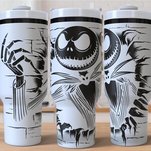 May include: White travel mug with a black and white illustration of Jack Skellington from The Nightmare Before Christmas. The design wraps around the mug, featuring a skeleton hand, Jack's face, and other spooky elements. The mug has a white handle and lid.