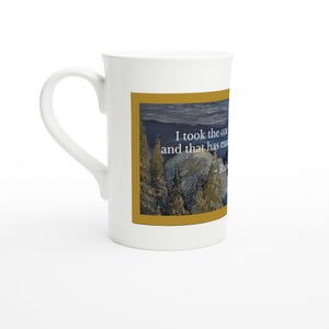 May include: White ceramic mug with a curved handle. The mug features a rectangular image with a landscape scene and text that reads "I took the one and that has ma..." The mug is on a white surface.