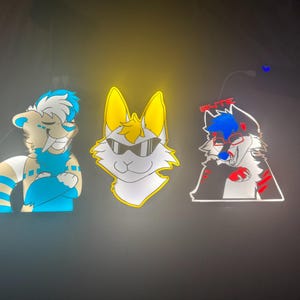 May include: Three cartoon animal character stickers. The first is a tan and blue bear-like character with arms crossed. The second is a white cat-like character with yellow ears and sunglasses. The third is a black and white wolf-like character with red accents and glasses.