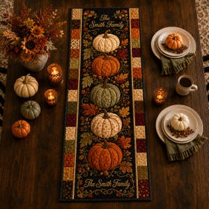 May include: A rectangular quilted table runner featuring a black background with a vertical row of five pumpkins in cream, orange, and green, surrounded by autumn leaves and the text The Smith Family at the top and bottom, bordered by a patchwork pattern.