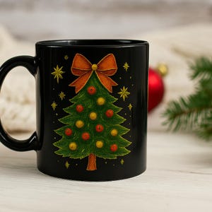 Puede incluir: Taza de cerámica negra con un diseño de árbol de Navidad. El árbol está decorado con adornos rojos y amarillos, coronado con un lazo naranja y rodeado de estrellas doradas. Una taza festiva para las fiestas.