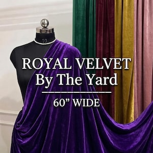 以下が含まれることがあります： 黒いマネキンにドレープされたロイヤルパープルのベルベット生地。テキスト「ROYAL VELVET By The Yard」と「60" WIDE」が表示されています。生地の幅は152cmです。背景には、緑、バーガンディ、ゴールド、ピンクのベルベットのパネルがあります。