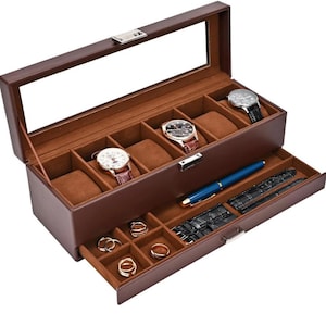 May include: A brown leather watch and jewelry box with a glass top. The top section holds five watches, while the bottom drawer contains rings, a pen, and watch straps. The interior is lined with a tan fabric.