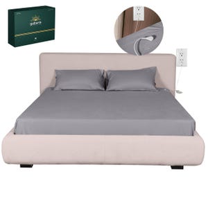 May include: A bed with a light beige upholstered headboard and frame, covered with a grey sheet set and pillows. A box with the text "goEarth" and a sun logo is in the upper left corner. An electrical outlet is visible.